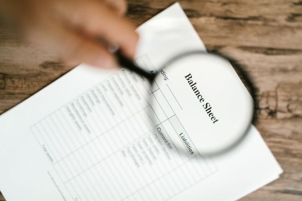 Magnifying glass over documents representing a worked prior art search example